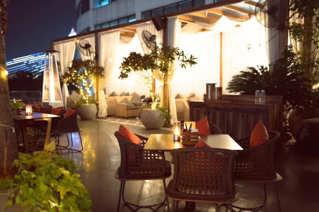 Outdoor seating and softly lit cabanas at Akan Brewing Co