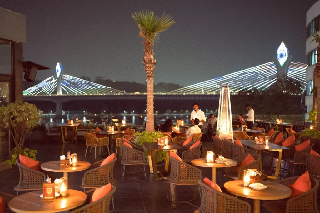 Akan’s rooftop seating overlooking the illuminated Durgam Cheruvu bridge