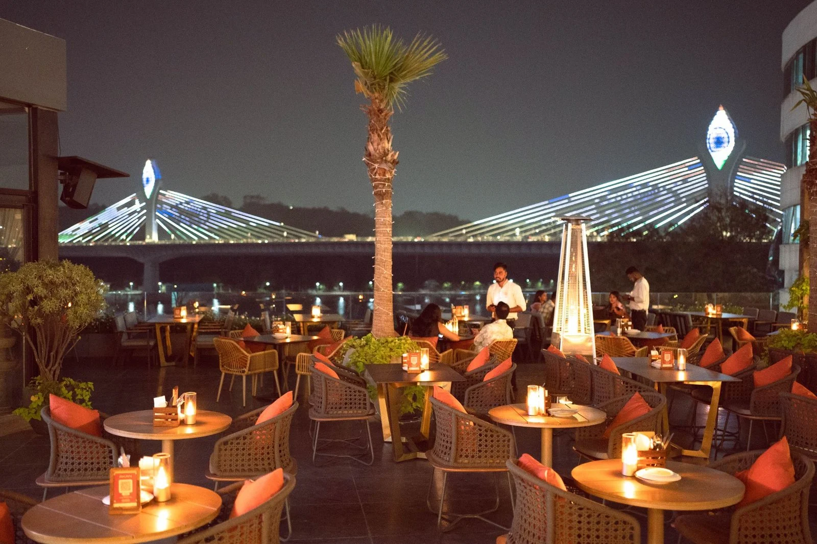 Akan’s rooftop seating overlooking the illuminated Durgam Cheruvu bridge